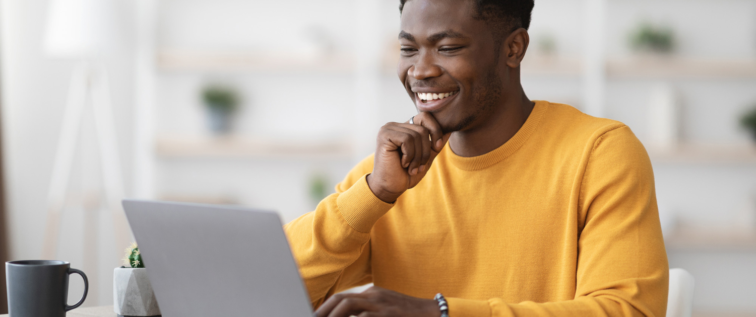 Side View Of Smiling Man On Laptop