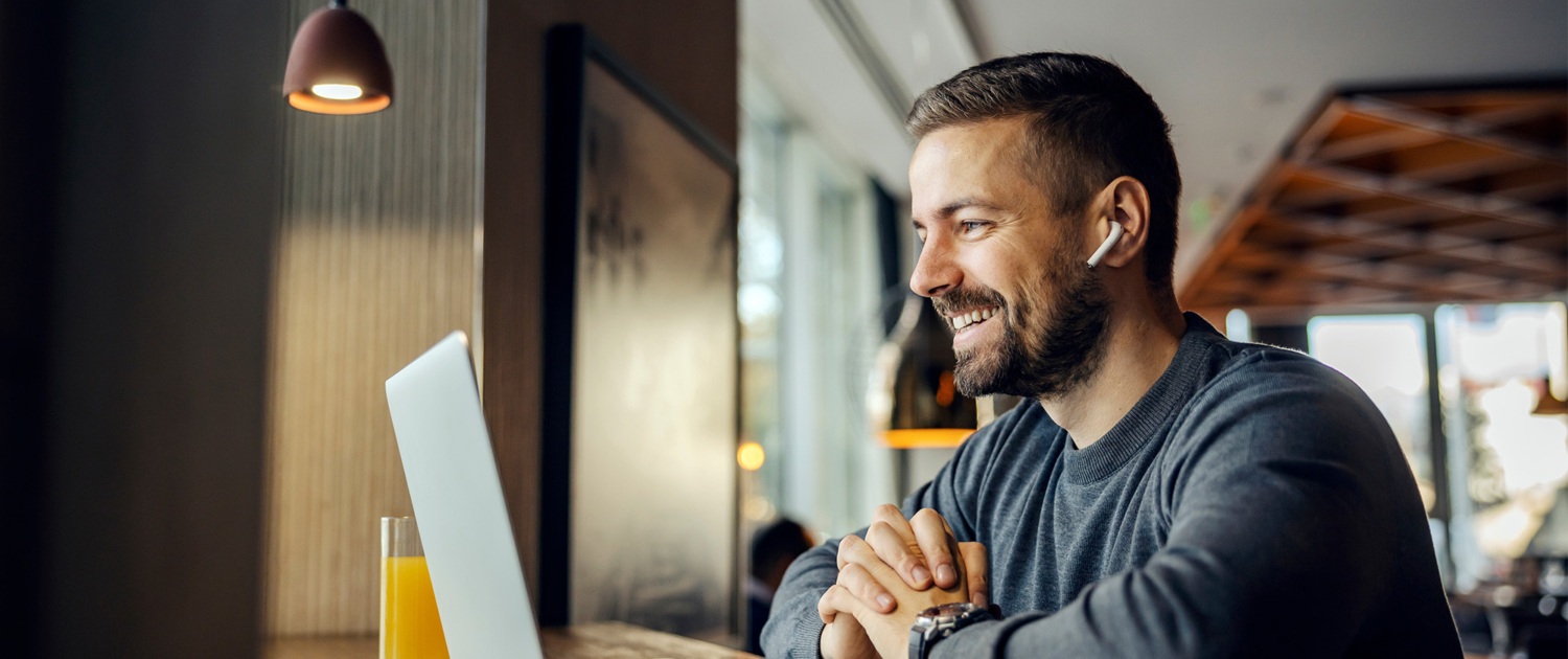 A Friendly Freelancer Is Sitting In A Coffee Shop And Having Conference Call With Client